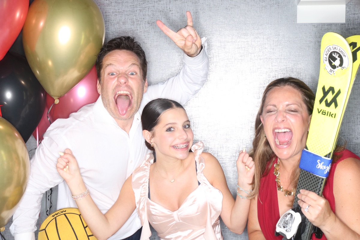 Photobooth: bat mitzvah girl and her parents with props