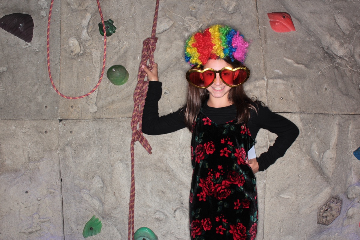 Photobooth: guest in a rainbow wig and giant heart glasses
